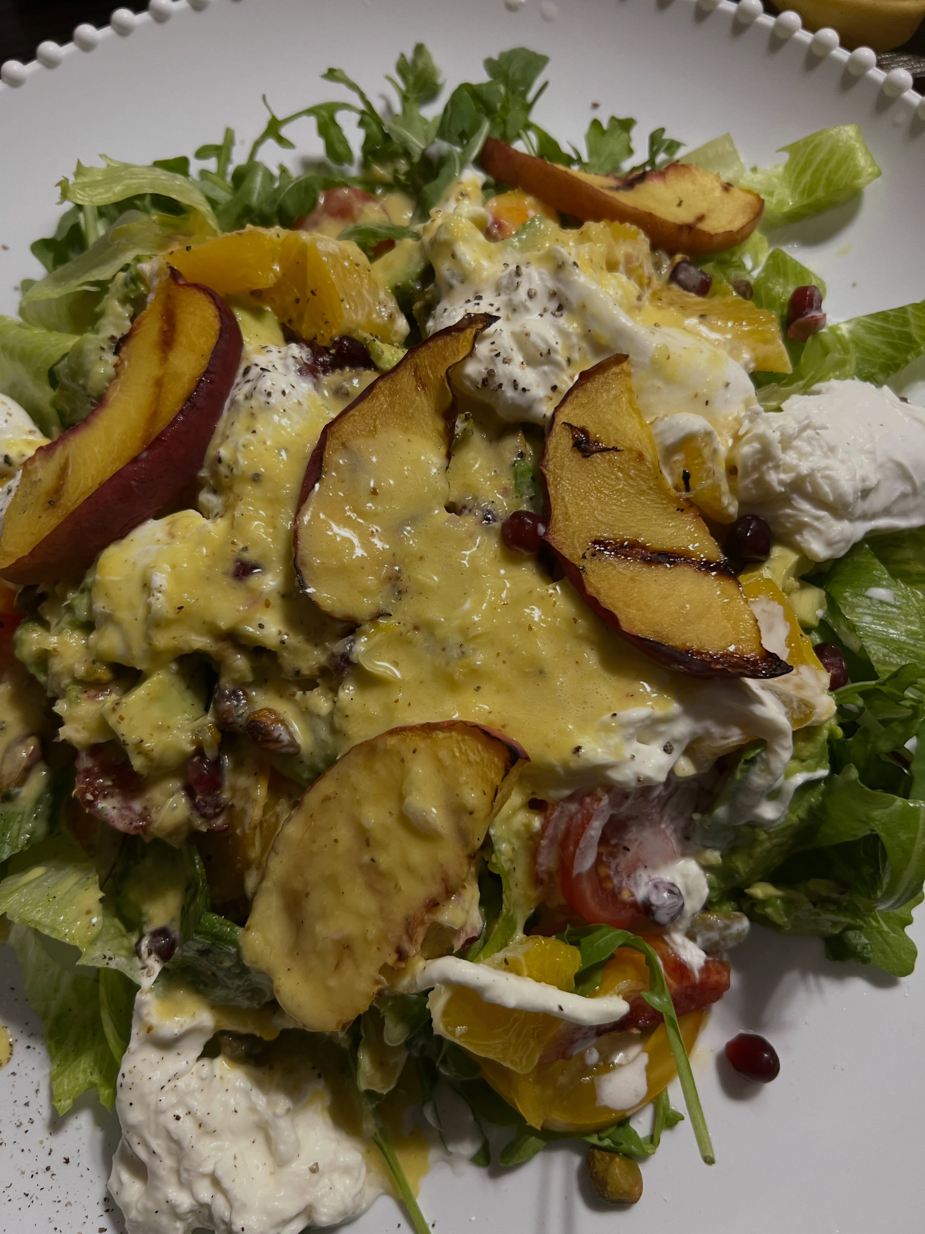 Grilled peach burrata salad w heirlooms, arugula, romaine, pomegranate, pistachios and orange honey citrus vinaigrette made from scratch. So so good.